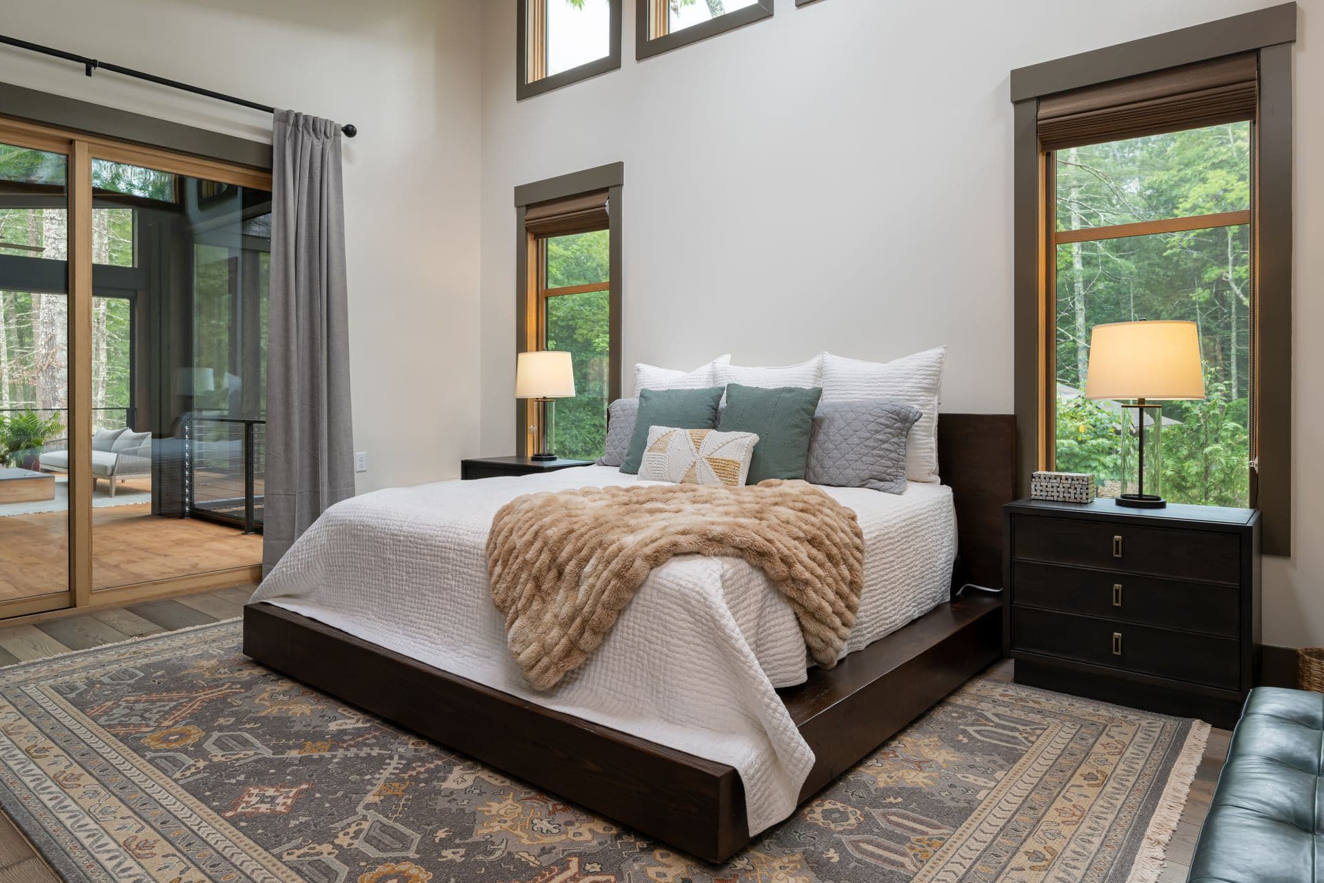 Bedroom with a low upholstered bed and views of the trees