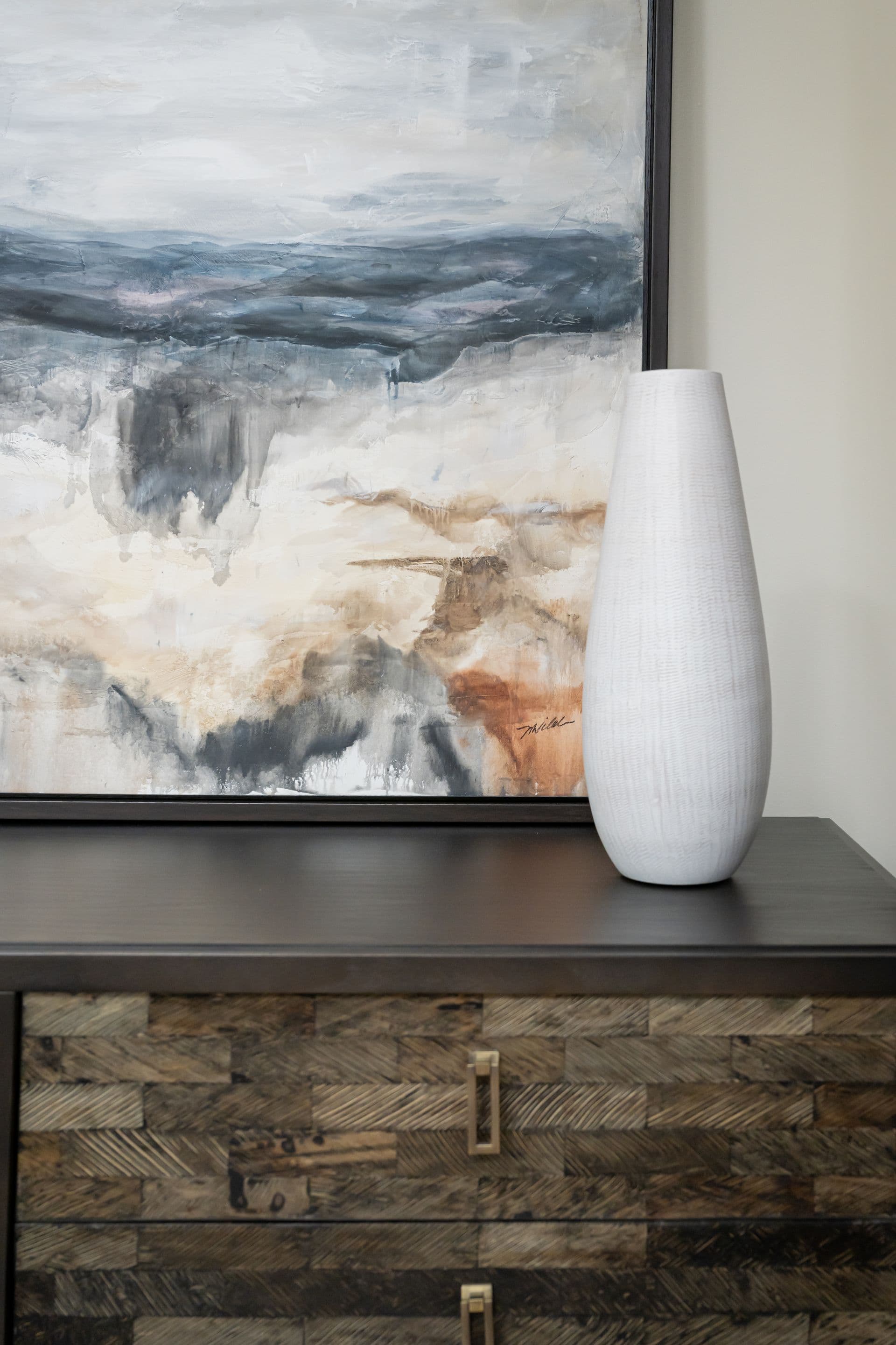 Textured vases and an abstract painting displayed above stonework