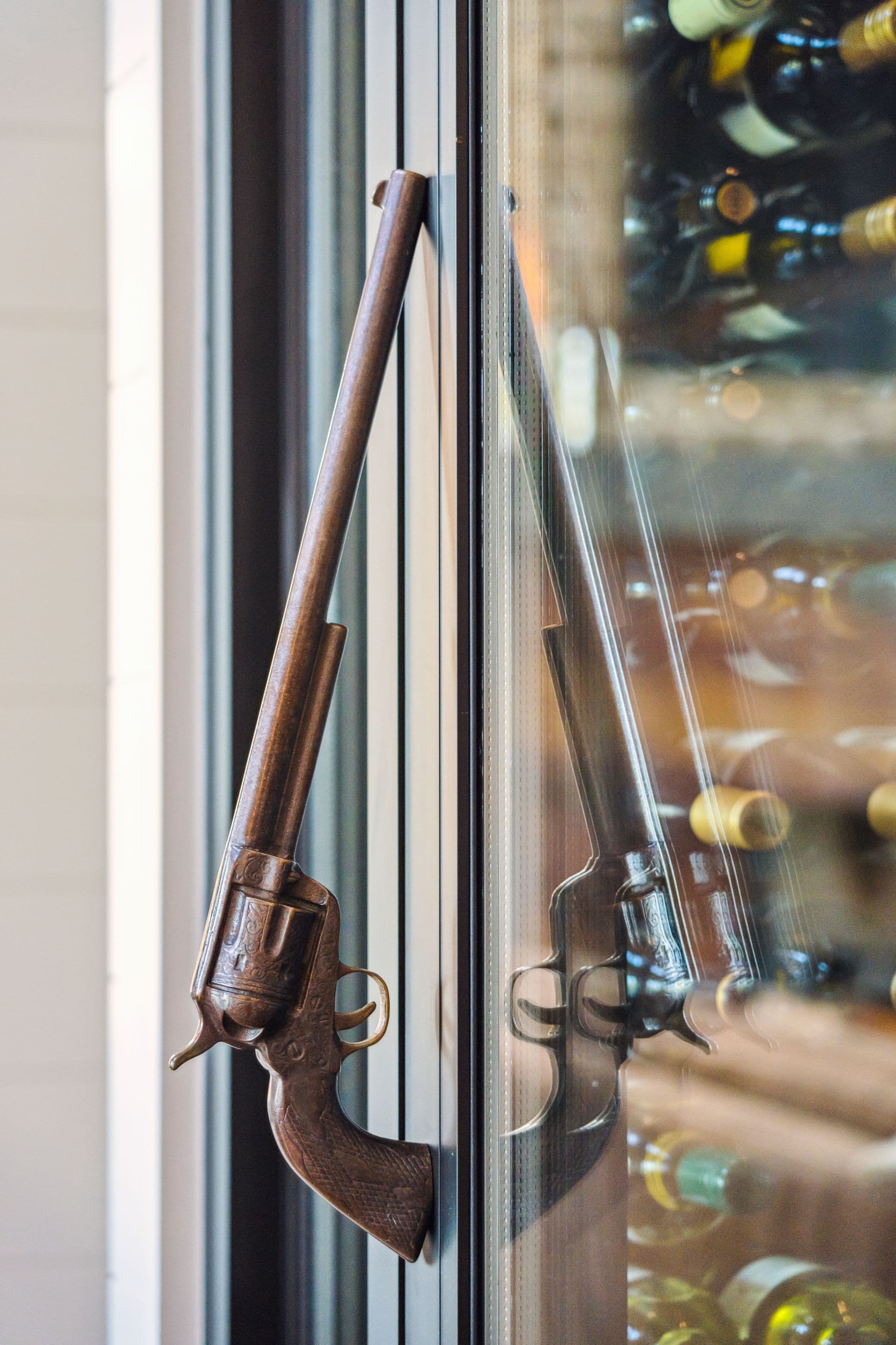 Antique gun-shaped handles on a glass wine cabinet