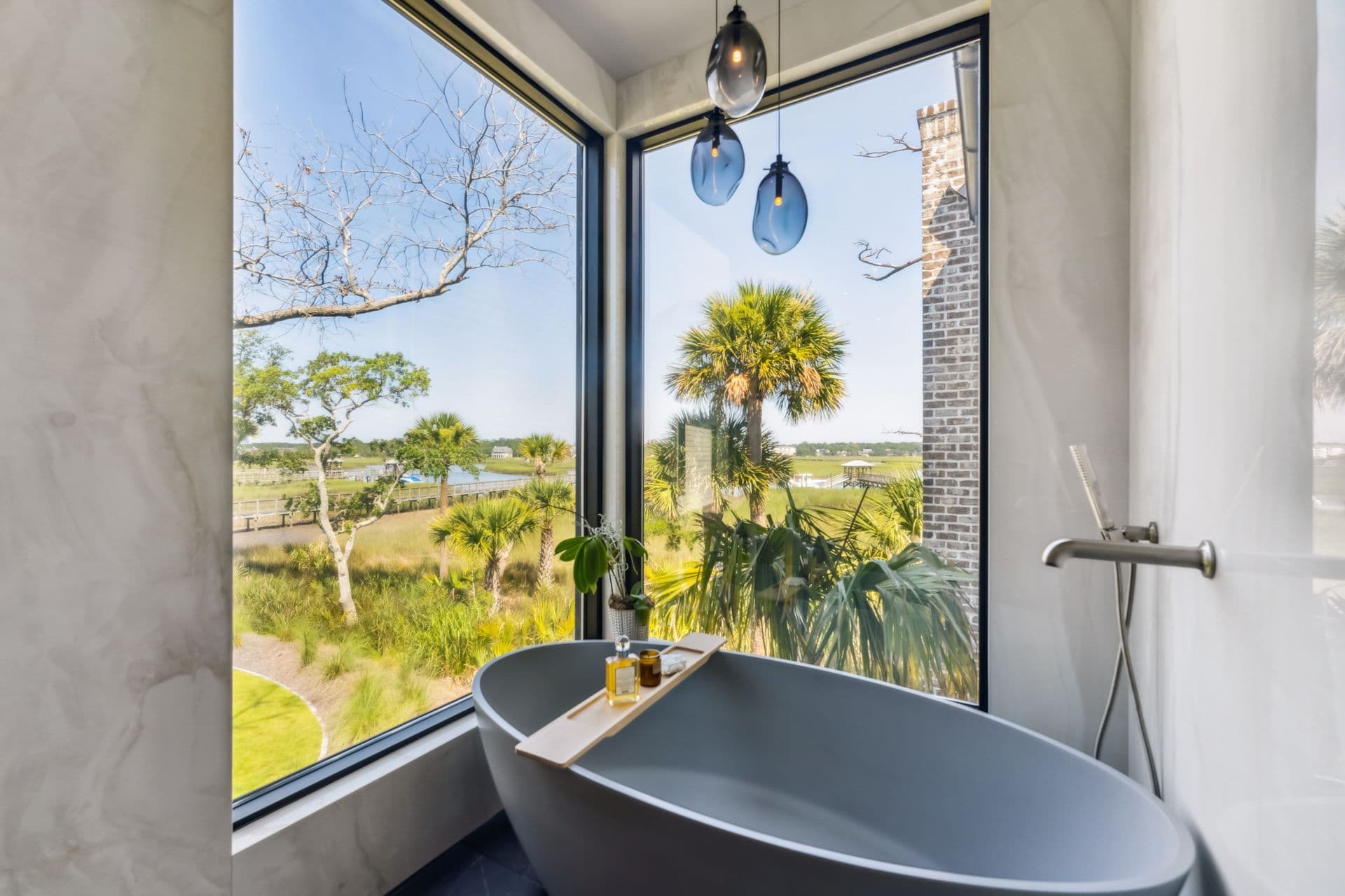 Freestanding bathtub overlooking palms and coastal marshes