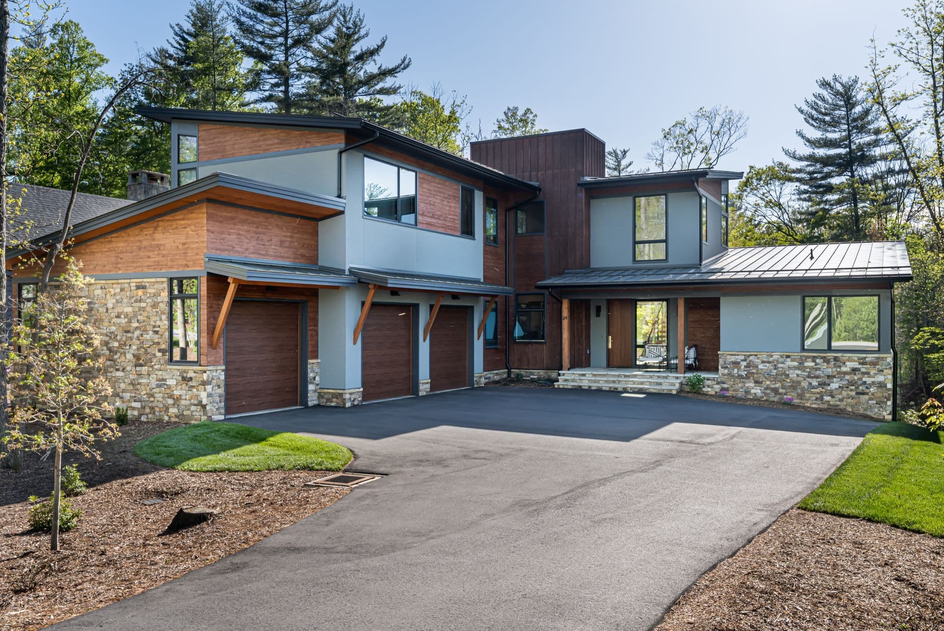 Organic modern home exterior framed by mature trees