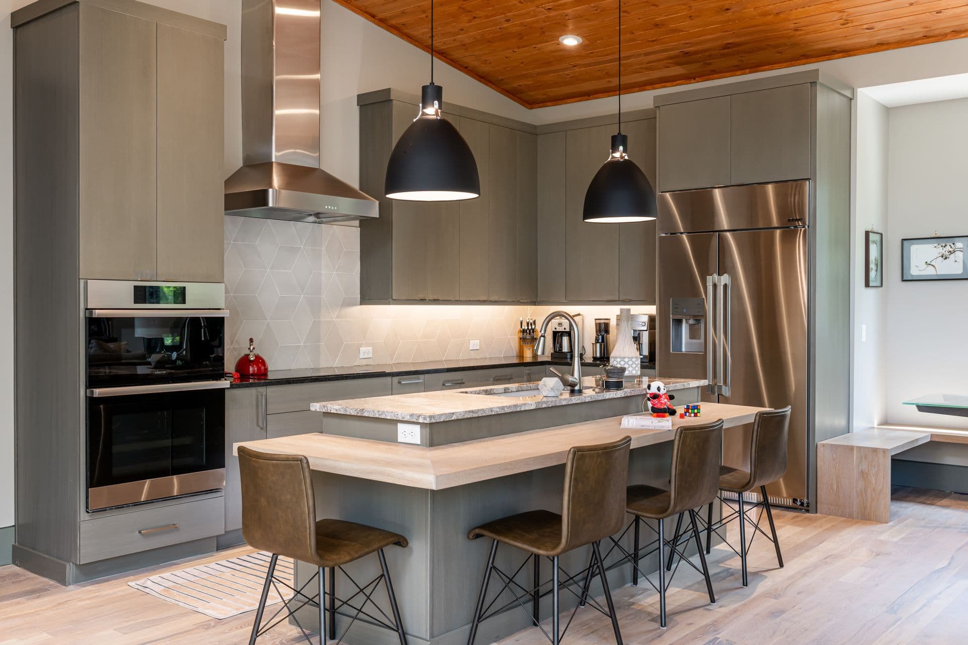 A modern kitchen with natural wood and sculptural pendant lighting